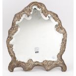 A late Victorian silver mounted strut backed mirror, of shaped rococo form,