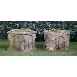 A pair of reconstituted stone pentagonal shaped garden planters, relief cast with figures in arches,