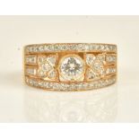 A gold and diamond ring, in a pierced panel shaped design,