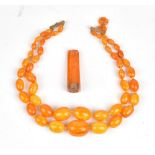 A two row necklace of varicoloured mottled butterscotch coloured graduated opaque oval amber beads,