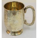 A silver mug, with a 'C' shaped handle, raised on a circular foot, Sheffield 1936, height 12cm,