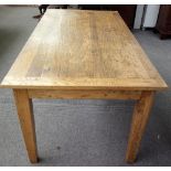 A modern distressed oak kitchen table, the cleated plank top on tapering square supports,