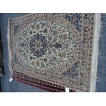 An Isfahan part silk rug, Persian, the ivory field with an indigo faceted medallion,