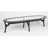 A black lacquered oval 'racetrack' coffee table, with glass inset top and undertier,