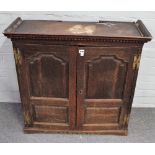 An 18th century oak hanging cupboard with pair of arched panel doors enclosing a fitted interior,