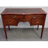 A George III style mahogany serpentine writing table with four frieze drawers on tapering square