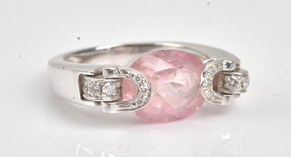 A diamond and pink tourmaline ring, mounted with the oval cut pink tourmaline to the centre,