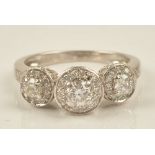 A white gold and diamond set ring, in a triple cluster design,