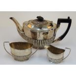 A silver composite three piece tea set, comprising; a late Victorian teapot with black fittings,