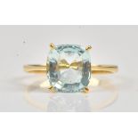 A gold ring, claw set with a cushion shaped aquamarine, detailed indistinctly 750, ring size Q,