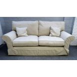 A modern three piece suite with loose cream upholstery to comprise a sofa, 207cm wide x 78cm high,