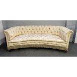 A late 19th / early 20th century faux silk upholstered concave Chesterfield style sofa on square