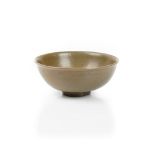 A Chinese celadon bowl, Yuan/Ming dynasty, covered in a deep olive green glaze, 19cm diameter.