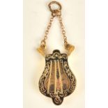 A Victorian gold and black enamelled pendant locket, designed as a lyre,