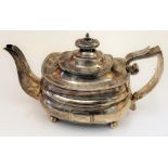 A George III silver teapot, of compressed boat shaped form, raised on four spherical feet,