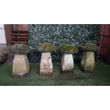 A set of four staddle stones with tapering square bodies and mushroom tops, each approx 70cm high,