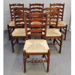 A set of six Lancashire ladder back rush seated dining chairs on turned supports,