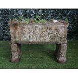 A reconstituted stone rectangular planter relief cast with cherubs resting on a pair of scroll