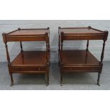 A pair of mahogany square two tier occasional tables with single drawer bases on turned supports,