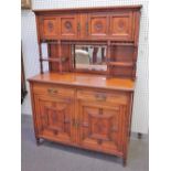 An Aesthetic Movement walnut side cabinet, with four flower carved doors over bevelled mirror,