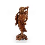 A Chinese carved wood figure of a man, 20th century, carved carrying a branch over his shoulder,
