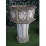 A reconstituted stone Gothic revival octagonal planter/font with relief quatrefoil panels,
