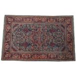 A Kashan rug, Persian, the indigo field with a madder and pale indigo medallion, matching spandrels,