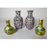 A pair of Chinese baluster vases, painted with flowers against a black ground, 17cm high,