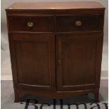 An early 19th century mahogany bowfront side cabinet, with two short drawers over cupboard base,