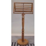 An early 20th century walnut duet music stand, with turned column base, 55cm wide x 134cm high.