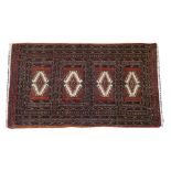 A Pakistan Bokhara rug, the brown field with four compartments, 167cm x 96cm.