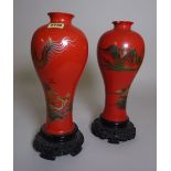 A pair of 20th century Asian orange lacquer vases decorated with dragons on carved bases,