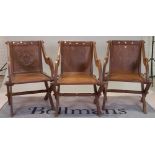 A group of three similar 20th century oak Glastonbury style chairs with solid backs and seats,