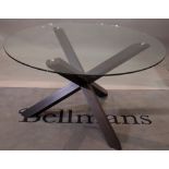 A glass circular dining table, on a stained beech 'X' frame base, 130cm diameter x 77cm high.