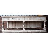 A early Victorian white painted pine dresser base with four frieze drawers on baluster supports and