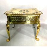 An early 19th century twin handled brass footman/trivet with pierced decoration and cabriole legs,