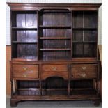 An early 20th century oak dresser with three tier plate rack over three frieze drawers,