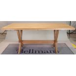 A modern oak rectangular dining table, on 'X' frame supports united by a stretcher,