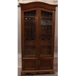 An early 20th century oak floor standing bookcase with lead lined glazed doors, over cupboard base,