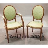 A set of nine Louis XVI style stained beech oval back dining chairs on fluted tapering supports,