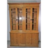 A modern pine floor standing display cabinet with four glazed doors over four door cupboard base.