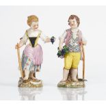 A pair of Meissen figures of child gardeners, 20th century, modelled as a boy and girl holding...