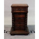 An 18th century style oak bedside table with three drawers flanked by spiral columns on pad feet