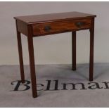 A George III mahogany single drawer side table on canted square supports