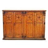 A Victorian oak Gothic Revival four door side cabinet on a plinth base, 183cm wide; 130cm high.