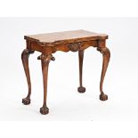 A mid-18th century style walnut consertina action card table, with dished gaming wells, on...