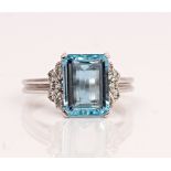 An 18ct white gold, aquamarine and diamond ring, claw set with the rectangular step cut...