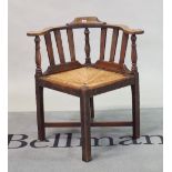 A 19th century oak corner chair with rush seat on block supports