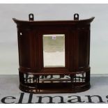 An Edwardian mahogany hanging cupboard with central bevelled mirror flanked by cupboard doors