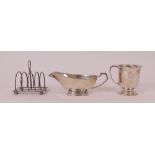 Silver, comprising; a sauce boat, raised on a curved rectangular foot, Birmingham 1940, a...